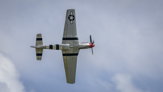 Biplane performing aerobatic stunt. Paint scheme of WWII Army Air Corp trainer. Stearman Kaydet.