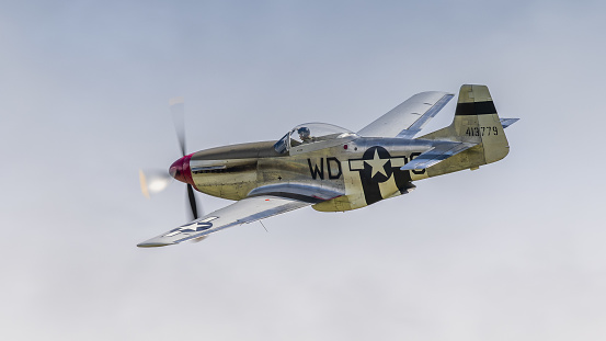 Cosford,UK - 12th June 2022: A Consolidated P51 Mustang fighter aircraft of world War Two vintage, in flight against a blue sky. Close up shot