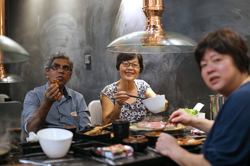 Asian family dining in restaurant for barbeque
