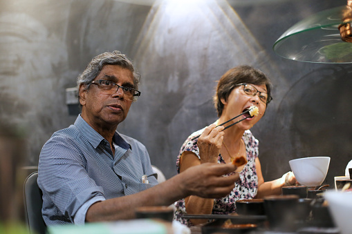 Asian family dining outside in restaurant for barbeque