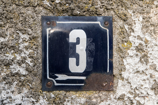 Weathered grunge square metal enameled plate of number of street address with number 3