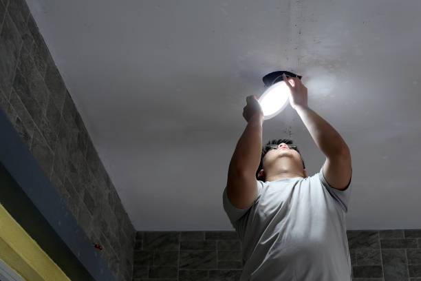 Handyman An Asian man is changing light fixtures at house's front porch light fixture stock pictures, royalty-free photos & images
