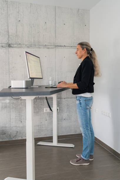 istock woman working at adjustable standing desk 1965086672