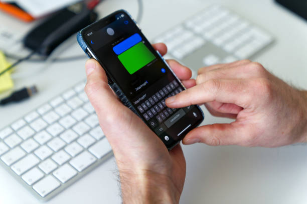 istock Male hands writing social media message with mobile phone with defocus background. 1965100205