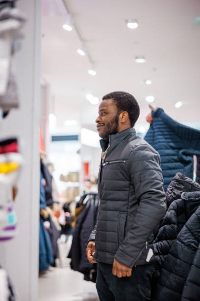 istock Smiling man tries new jacket for winter 1965117587