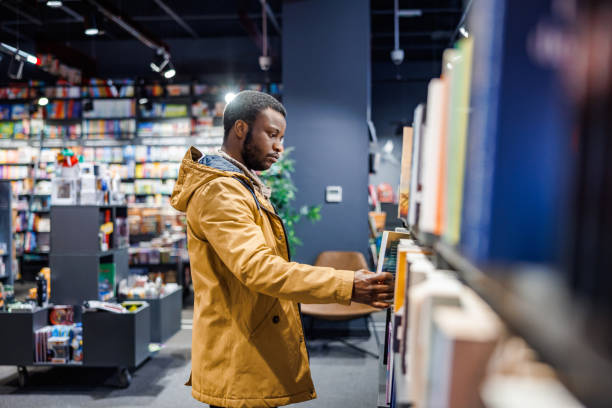 istock Man chooses books in bookstore 1965119760