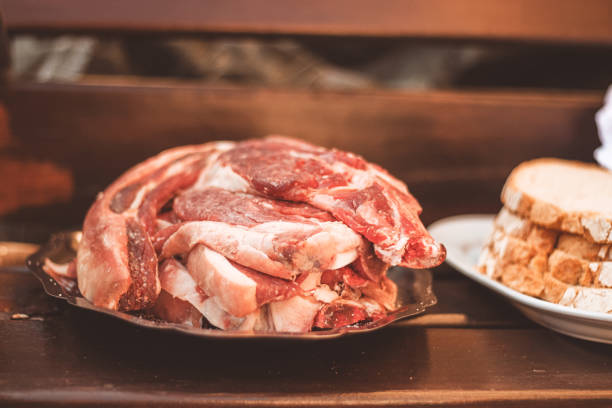 several raw beef entrecote on a silver tray, with the bread next to it