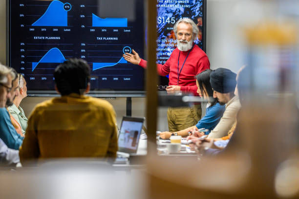 istock Senior man presenting report in meeting room 1965144518