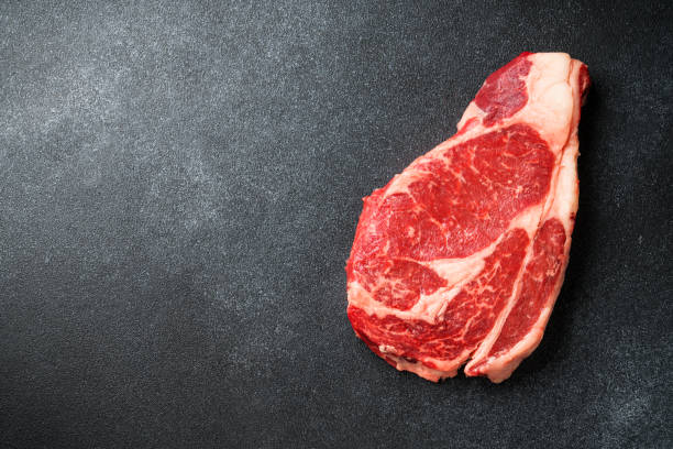 Beef steak, raw meat on black.