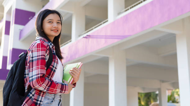 istock Asian girl hold book and backpack at school. 1965208469