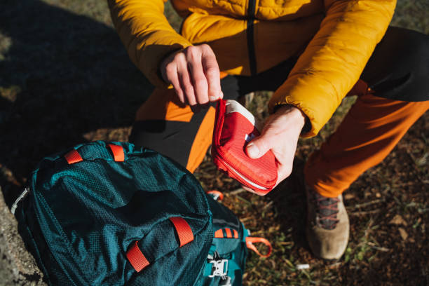 istock Open a first aid kit with medicines, a hiker on a hike uses a first aid kit, tourist equipment, survival in the forest. 1965211652