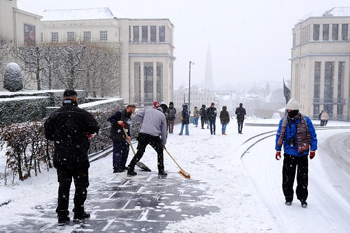 Workers clean up the snow of the streets  in central Brussels during a heavy snowfall in Belgium on January 17, 2024.