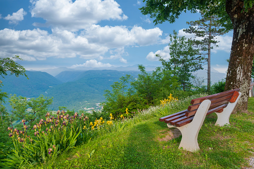 Wooden bench with a mountain view. Scenery of Soca valley, Slovenia, popular summer travel destination in Europe.
