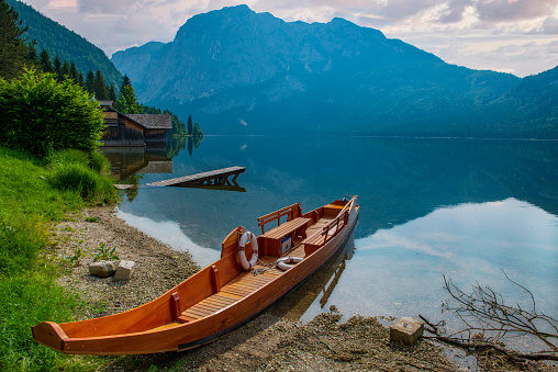 Idyllic scene on the alpine lake. Picturesque scene with wooden boat and pier on Altausse lake, Loser, Austria