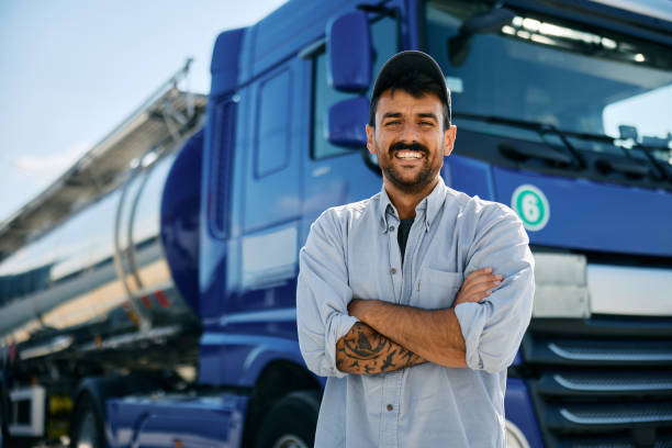 istock Confident truck driver in front of his vehicle looking at camera. 1965298749