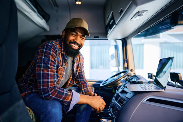 istock Happy black truck driver using laptop and looking at camera. 1965302457