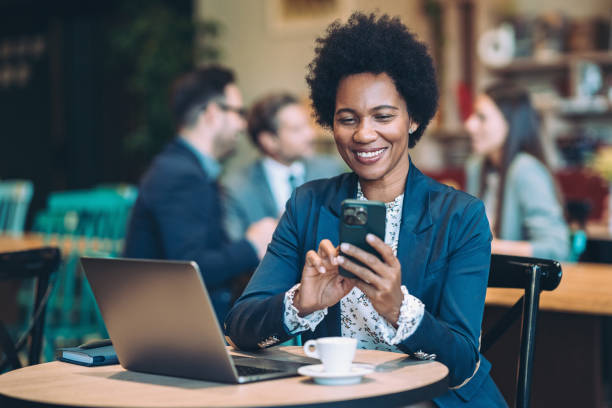 istock Smiling businesswoman using cell phone during lunch 1965304578