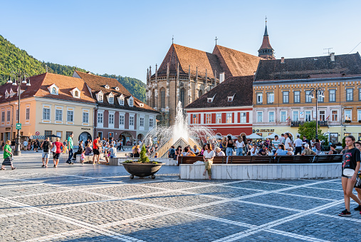 Brasov, Romania - September 02.2023: Tourists and locals strolling on the pedestrian area in the old town center of Brasov. City hall building in Council Square.