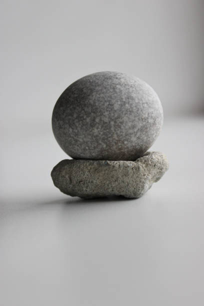 immagine concettuale di equilibrio. pietra rotonda liscia su un'altra pietra porosa - equanimity foto e immagini stock