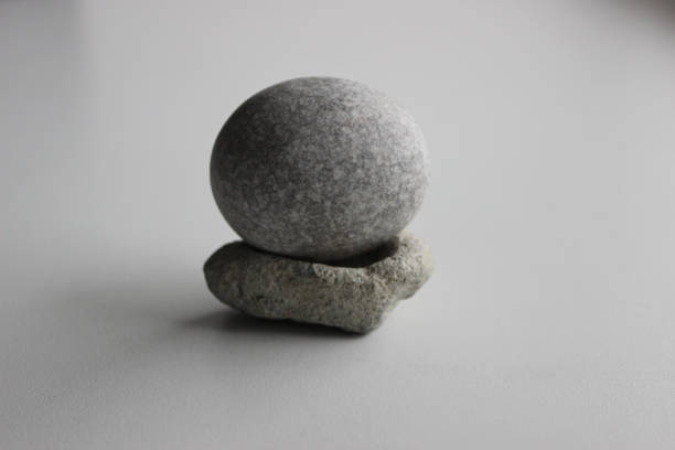 equilibri ovali perfetti della pietra del granito sul basamento di pietra isolato su bianco - equanimity foto e immagini stock
