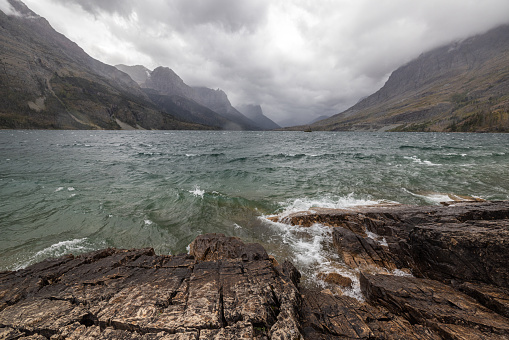 Stormy weather in glacier National Park viewed from the base of St Mary with choppy water and a very dramatic landscape.