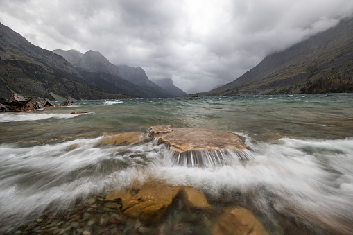 Stormy weather in glacier National Park viewed from the base of St Mary with choppy water and a very dramatic landscape.