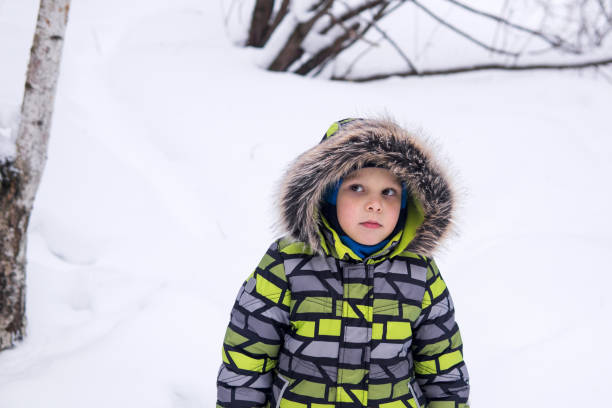 istock little boy walking in winter snowy park 1965394549