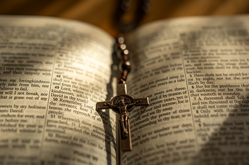 A rosary laying on an open Bible.