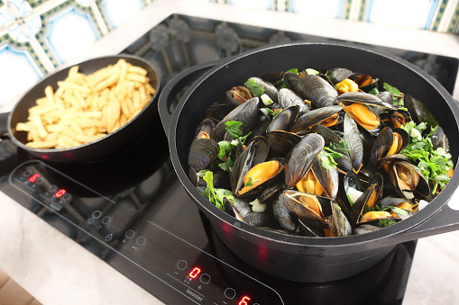 Mussels marinara with french fries being cooked  French cuisine