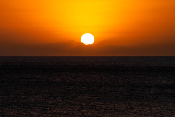 istock the sun is setting over the ocean on a dark day 1965434528