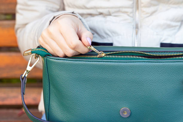istock woman's hand opens the zipper on a lady's bag 1965441293