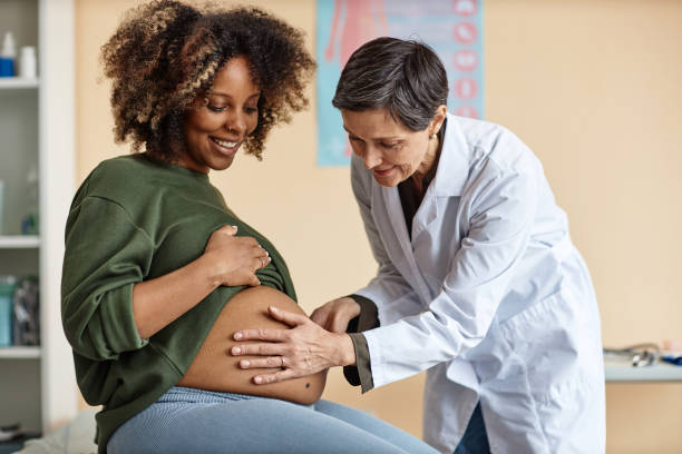 istock Female Obstetrician Checking Expectant Mothers Belly 1965472229