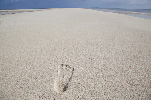 Footprints in the  white sand, sea in distance. Shoab beach, Soqotra, Yemen.
