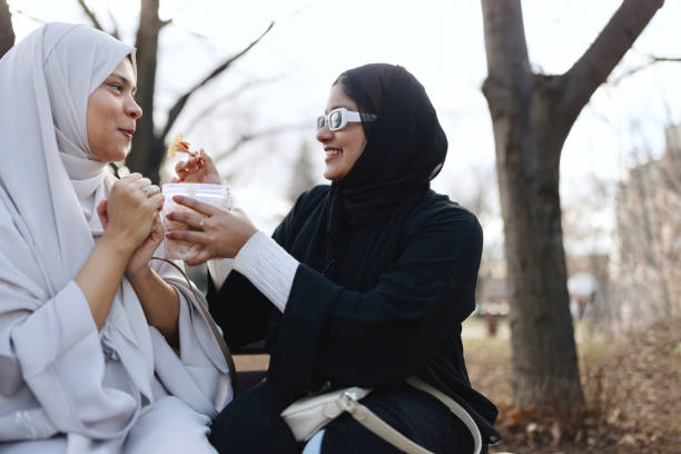 istock Women in hijab sharing food 1965517338