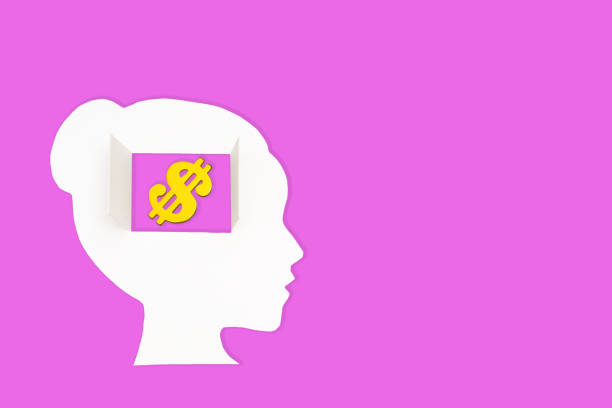 White paper-cut female head, set against a vibrant pink backdrop, features a window in the brain area revealing a golden dollar sign. Mindful approach to personal and financial decision-making.