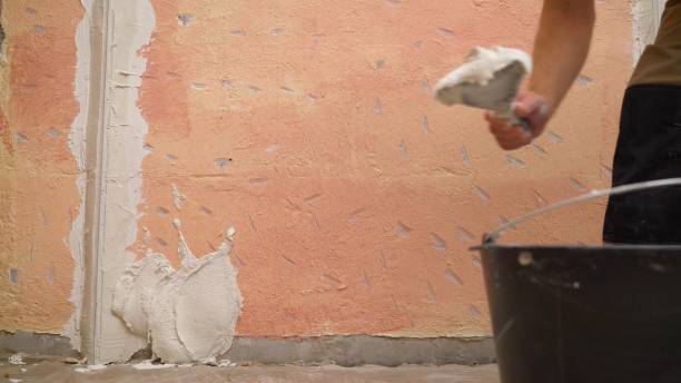 istock Plasterer putting plaster on wall. Putting plaster on the wall. Stucco between the holes. 1965643209