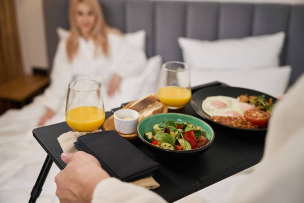 istock Young husband carries a breakfast tray to bed 1965695627