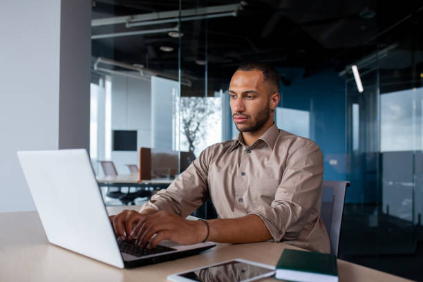 istock Serious concentrated man working inside office at workplace, businessman typing on laptop keyboard, programmer developing new software 1965705176