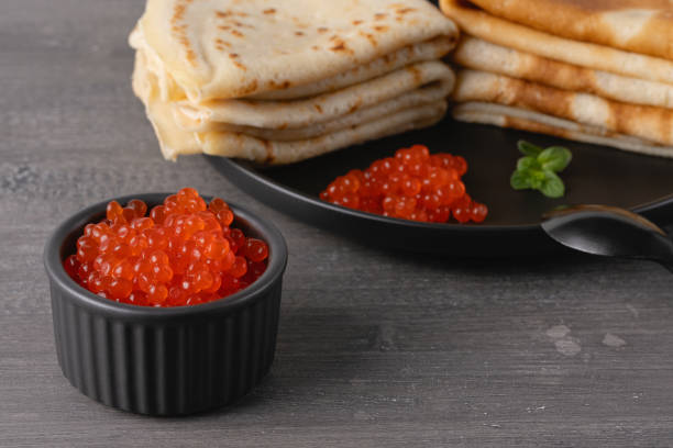 pancakes with red caviar. close-up of pancakes stacked on grey background - blinis photos et images de collection