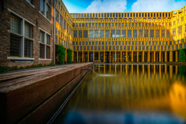 an image of a building next to a pond and a bench