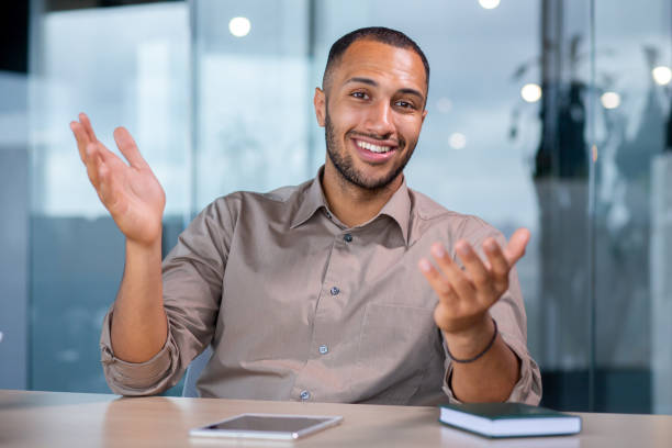 istock Attractive hispanic businessman having video call in office, gesturing with hands, smiling, talking to clients, webcam view 1965711058