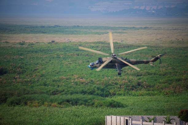 Entebbe, Uganda - 01 17 2024: A military attack helicopter of the Uganda army flying by near Lake Victoria close to the ground