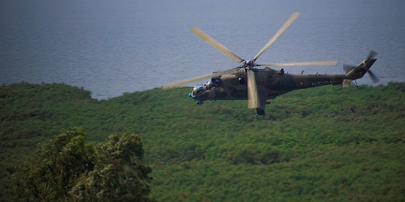Entebbe, Uganda - 01 17 2024: A military attack helicopter of the Uganda army flying by near Lake Victoria close to the ground