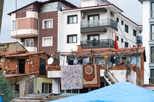 The view that draws attention to the problem of unplanned urbanization. A view of the laundry hanging on a line and a ruined tent in the front, and a high-rise luxury building behind it. Taken in daylight with a full frame camera.