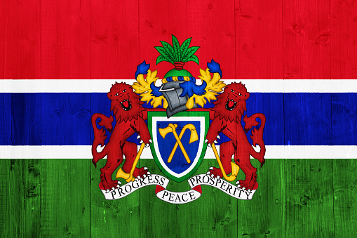 Flag and coat of arms of Republic of Gambia on a textured background. Concept collage.
