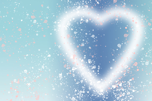 Glowing heart shape with lots of glittering particles on a blue background. Space for copy. Can be used as a template for romantic, Valentine's day holiday greeting cards or posters.