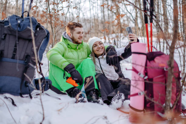 istock Couple taking a break from hiking on snow during winter days 1965825889