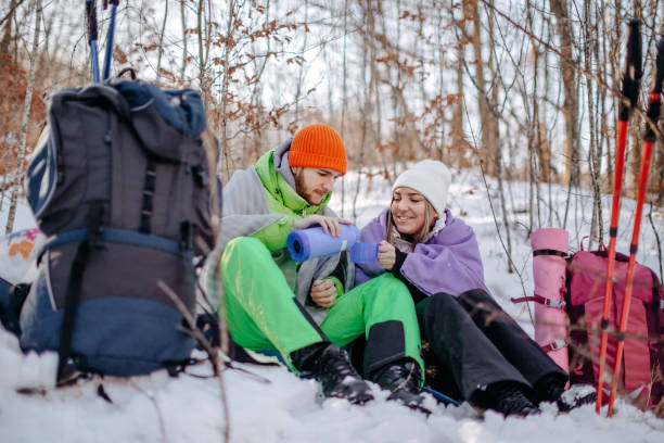 istock Couple taking a break from hiking on snow during winter days having refreshment drink 1965826188