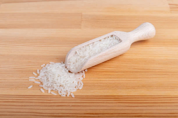 Heap of rice with a wooden spoon on a table