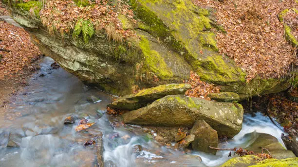 Photo of Icy Stream Flowing down Stone Cliffs